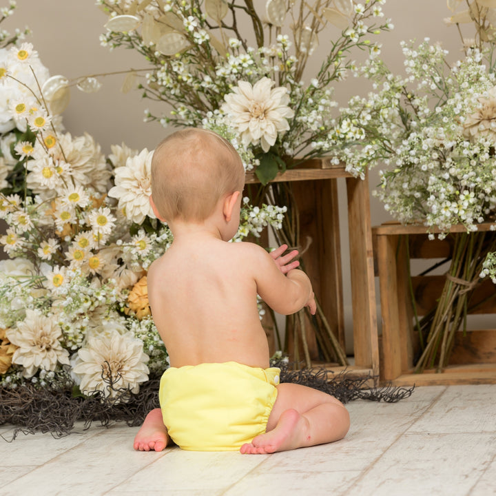 Baby wearing Onesize Reusable Pocket Nappy in Primrose Yellow by LittleLamb#color_primrose