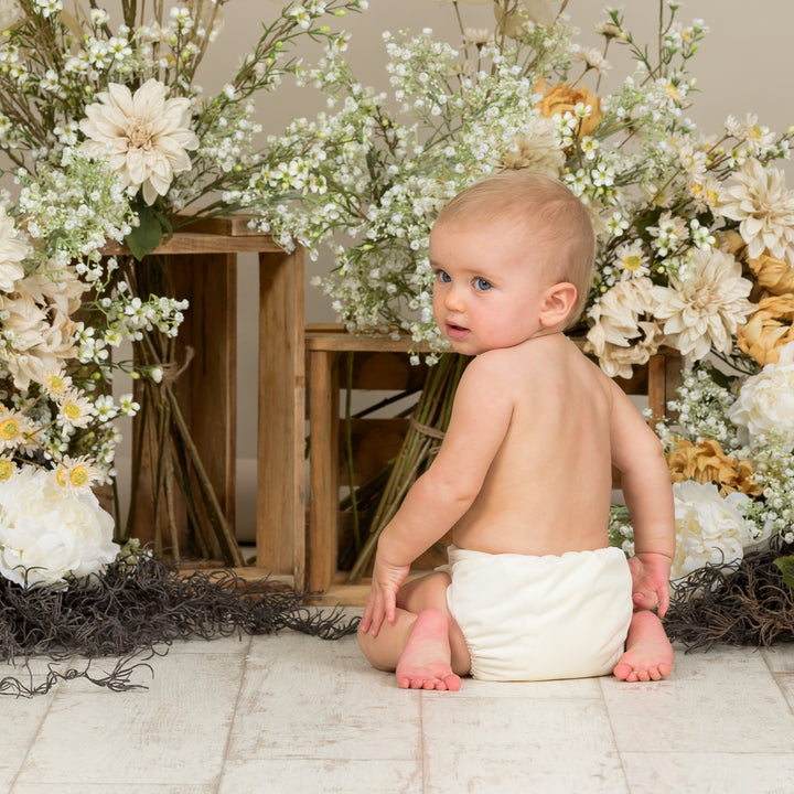 Baby wearing Onesize Reusable Pocket Nappy in cream by LittleLamb#color_cream