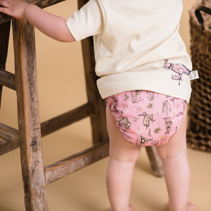 Little Baby holding onto a chair wearing Onesize Reusable Pocket Nappy with Hare illustrations by LittleLamb#color_moongazer